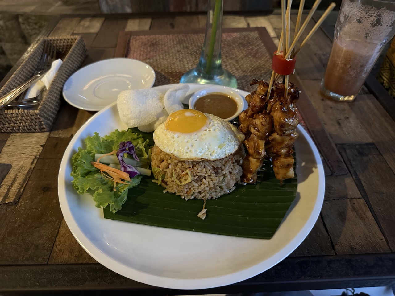 Nasi goreng, served with a fried egg on top and some ayam (chicken) satay