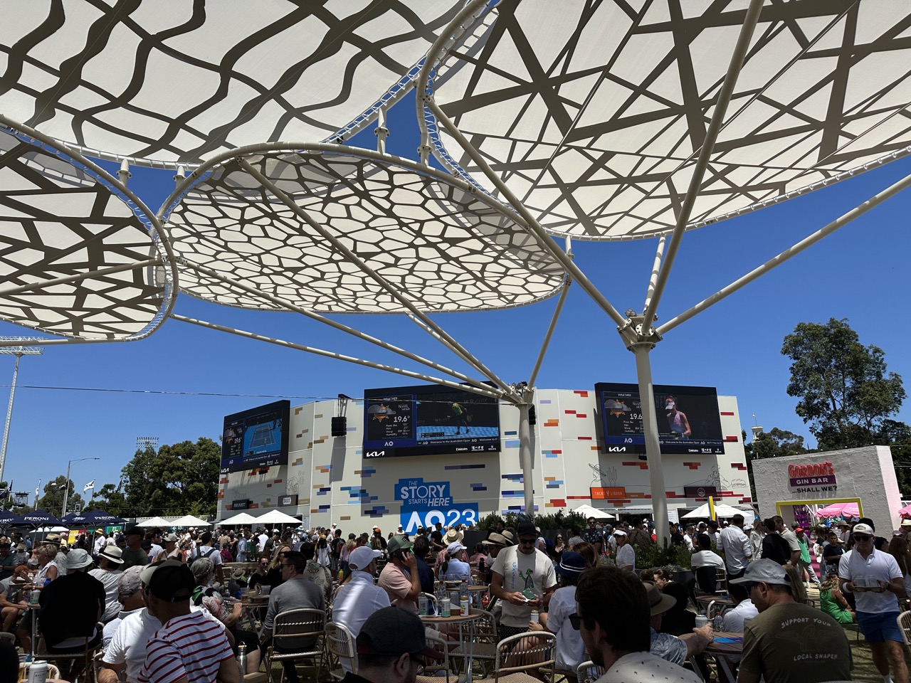 Inside of Grand Slam Oval there is lots of seating, many food stands, and TVs to watch the tennis