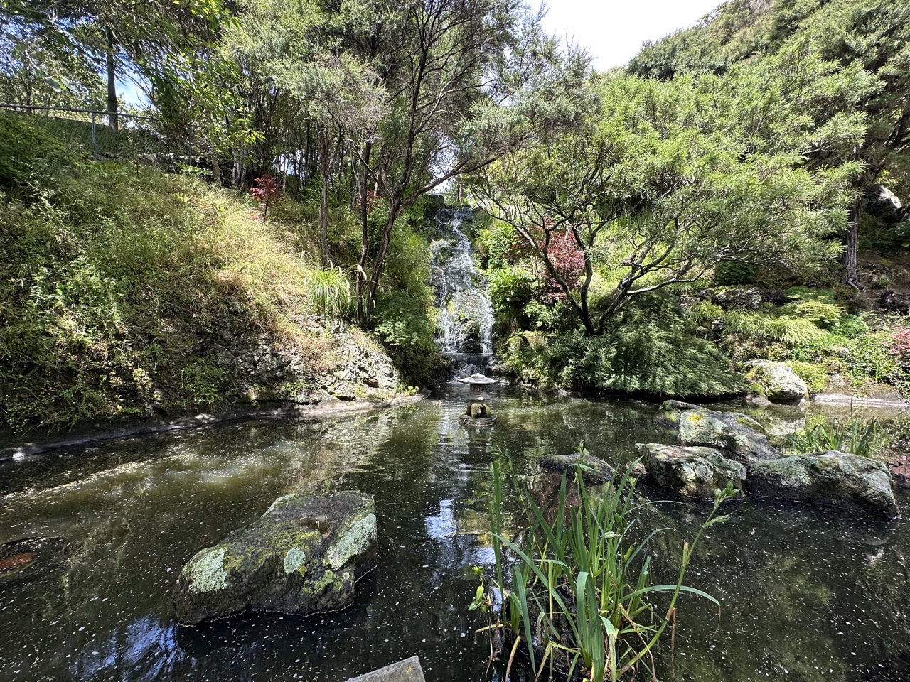 Waterfall at the Botanic Gardens with peace flame in front, dedication to nuclear disarmament