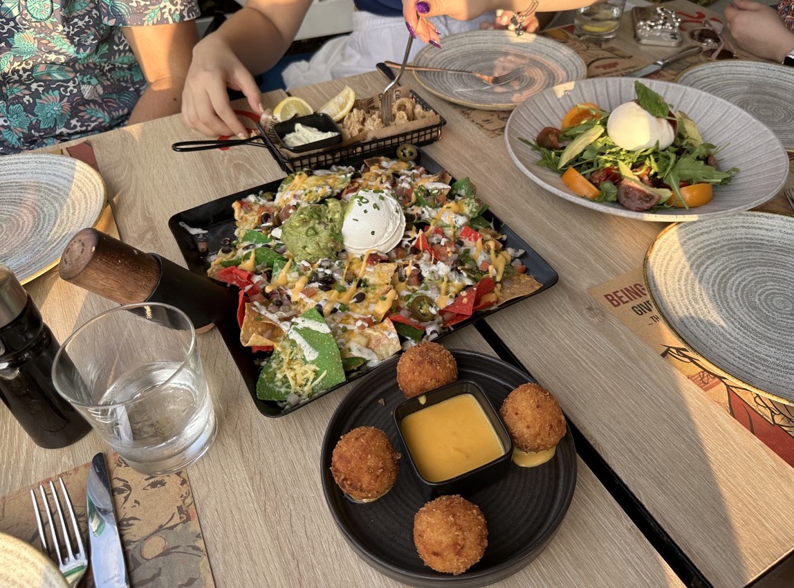 An assortment of dishes: calamari, salad, mac 'n cheese bites, and nachos