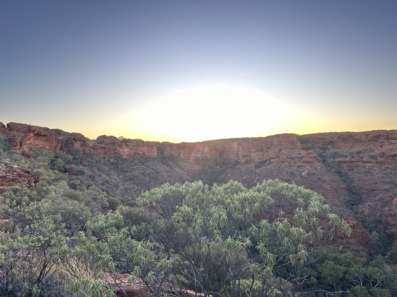 View of the sun peeking up above the ridge from the top of Heart Attack Hill