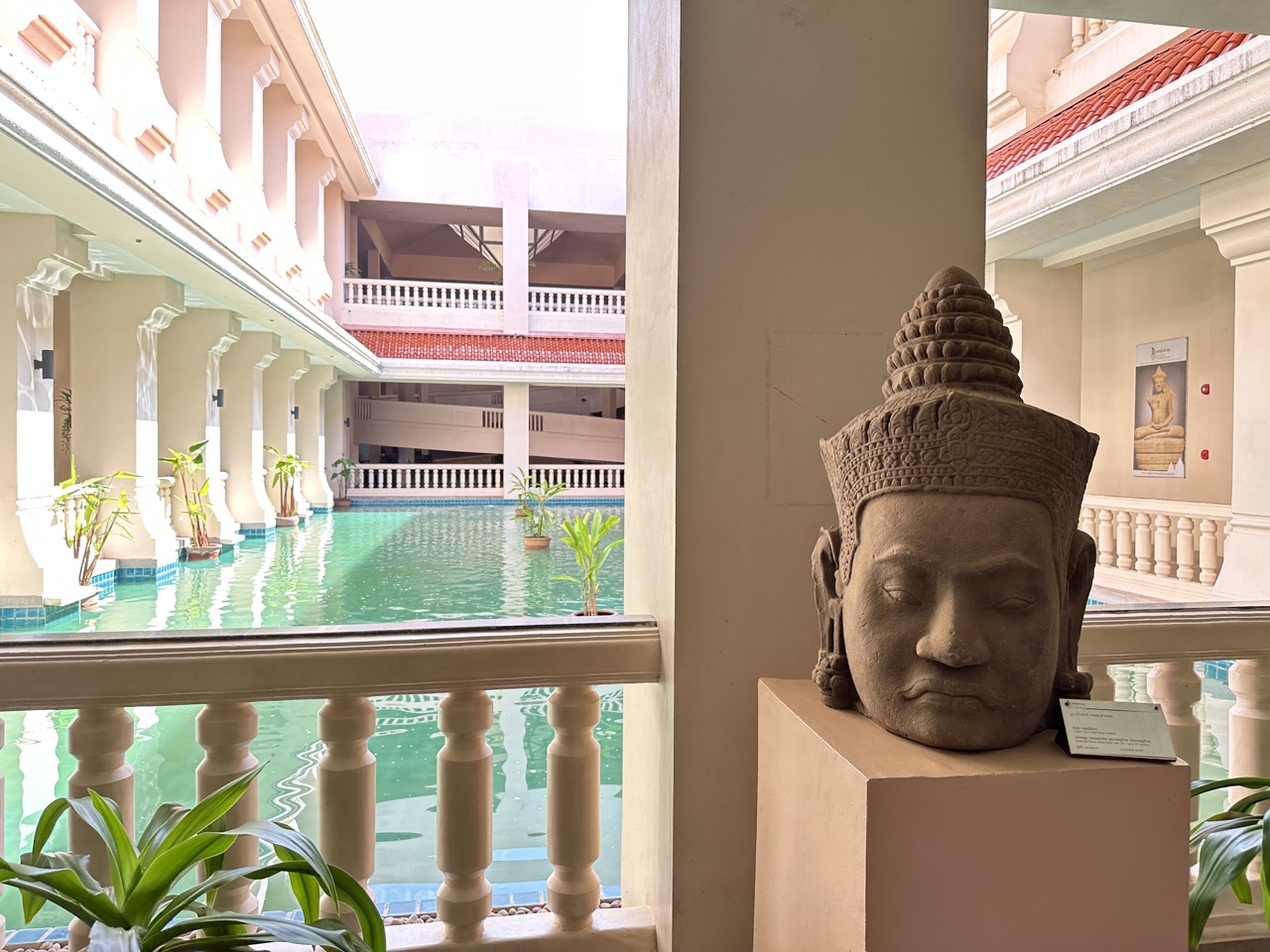 A Buddha head in front of the large pool in the museum's courtyard