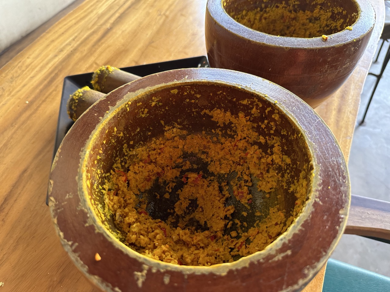 I used a mortar and pestle to grind up a mixture of turmeric, red chili, garlic, shallot, lemongrass, and ginger